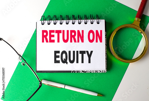 RETURN ON EQUITY text on notebook on green paper