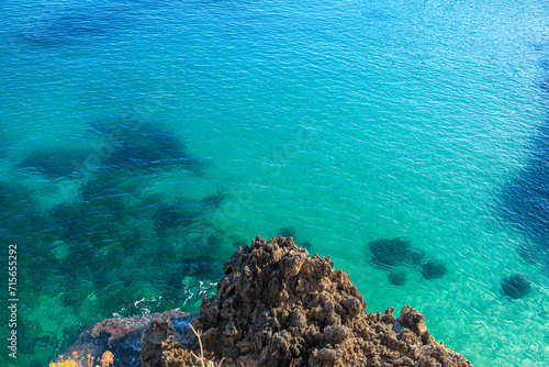 Rock on emerald sea in Apulia, Italy.
