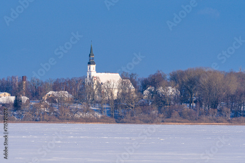 Church in the snow. Wintry Lutheran Church Emerges Above the Trees. 