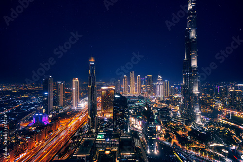 Aerial top view Dubai, night amazing skyline cityscape with illuminated skyscrapers, neon color. Modern downtown United Arab Emirates, sky with stars