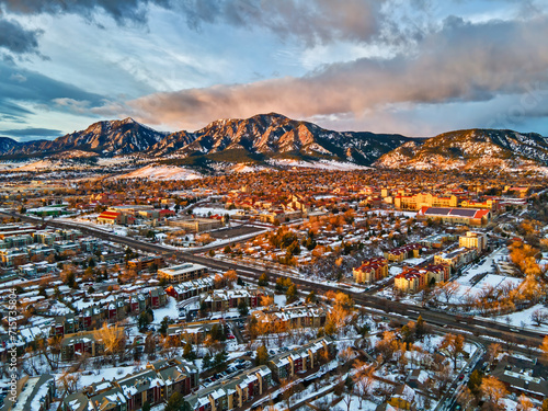 Drone view of University of Colorado, Boulder and the Flatirons at sunrise in the winter snow.