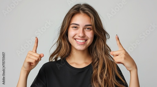 Portrait of an American woman in black t shirt indicating two forefingers up in a clean backdrop with copy space, Generative AI.