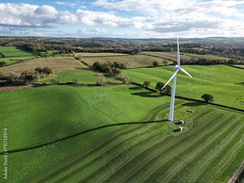 Aerial drone shot of an onshore wind turbine in the field on farmland in daytime