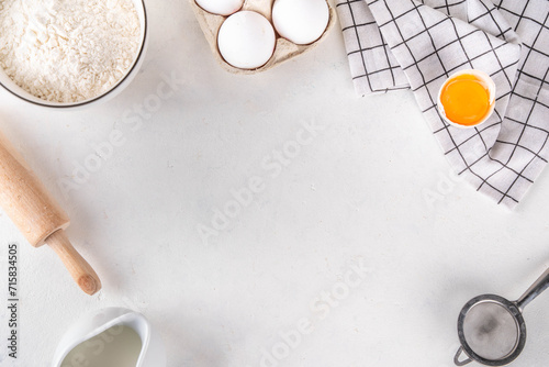 Empty space baking background with bakery ingredients - flour, milk, eggs, rolling pin. Simple pastry baking flat lay top view border