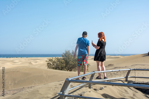 Two teenagers stand in the sand dunes of Maspalomas on Gran Canaria, Spain