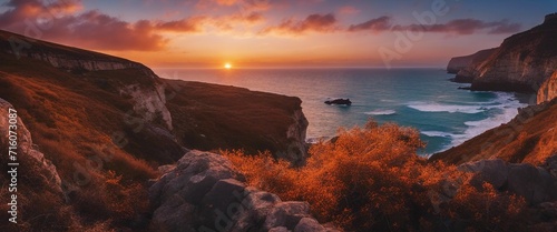 Coastal Cliffs at Sunset, the cliffs a dramatic contrast against the fiery sky, the ocean below