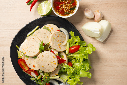 Flat-lay Spicy Vietnamese sausage salad tasty street food on wooden background