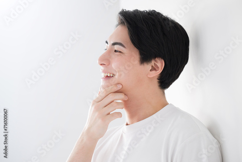 顎を触るアジア系（日本人）男性 爽やかな脱毛やスキンケアのイメージ クローズアップ