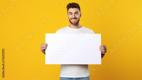 a handsome man holding a blank placard sign poster paper in his hands