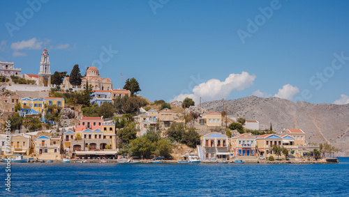 Symi Island, Greece. Greece islands holidays from Rhodos in Aegean Sea. Colorful neoclassical houses in bay of Symi. Holiday travel background.