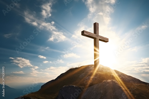 Wooden religious cross at top of mountain hill with sunbeams