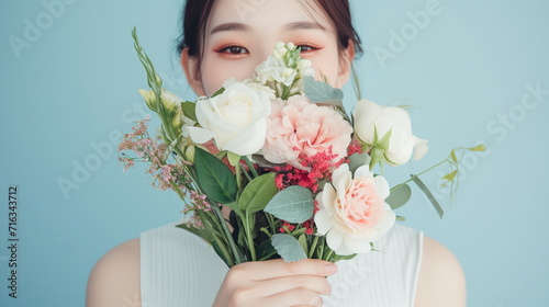 Beautiful asian woman with a bouquet of flowers. studio green background. copy space -Generative AI