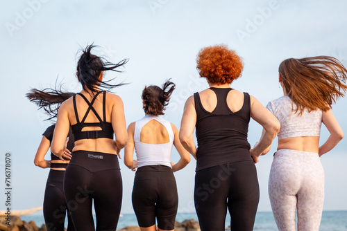 Wellness. Rear view of group of jogging women. Close up of backs. Concept of healthy lifestyle and cardio fitness class