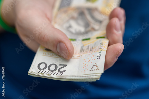 Dawać pieniądze, polska gotówka pln w dłoni z bliska