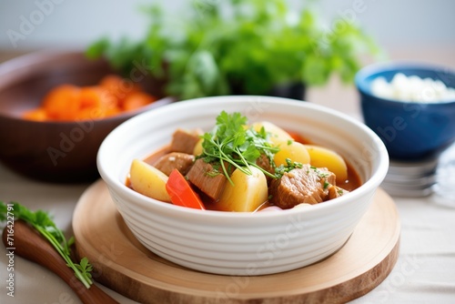 goulash in a bowl with golden potatoes and carrot pieces