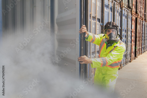 male rescue worker ppe wearing mask protection inspects tank containing dangerous poison illegal shipping containers prevent toxic dangerous gas in the loading yard dock gently open the door cover.