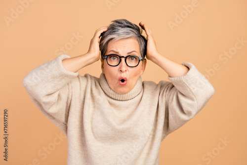 Portrait of crazy impressed lady arms touch head pouted lips cant believe isolated on beige color background