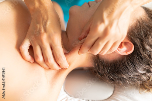 A physical therapist massages the sternocleidomastoid muscle in her patient's neck to decrease tension and pain