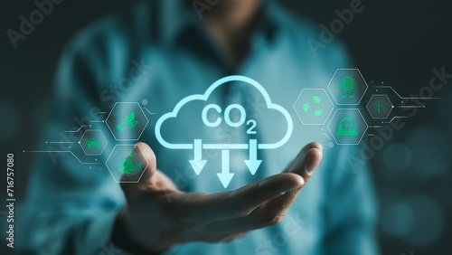 Carbon footprint concept. Man hand holding carbon reduction icon. Net zero and carbon neutral, Carbon emissions, CO2 neutrality, Sustainable energy, Climate change, Global warming, Greenhouse gas,