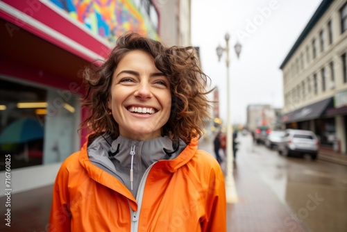 Portrait of a joyful woman in her 30s wearing a functional windbreaker against a vibrant market street background. AI Generation