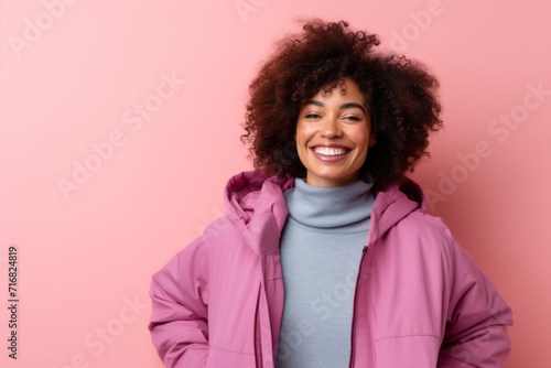 Portrait of a satisfied afro-american woman in her 30s sporting a quilted insulated jacket against a pastel or soft colors background. AI Generation