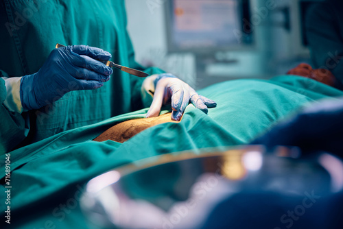 Close up of doctor using scalpel during surgery in operating room.