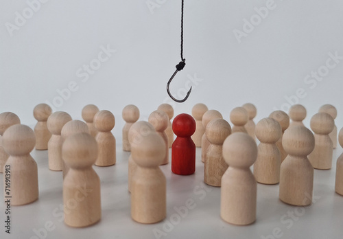 Hand with hook pulls red human figure out of crowd