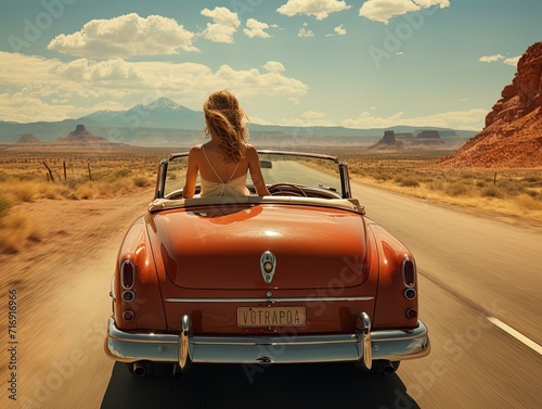 Woman sitting waiting in an old convertible from the 60s on the desert route. Vintage image.