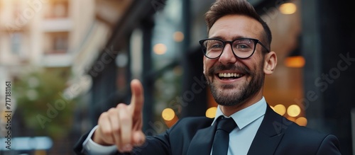 Fashionable businessman smiling, offering work, professional employee with corporate attire, pointing as marketing manager emphasizing product placement.