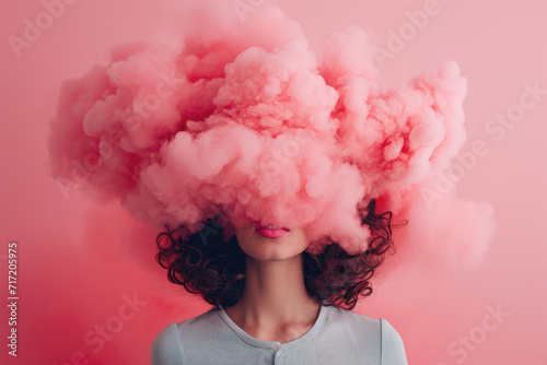 a young woman with her head in pink cloud on a pastel pink background 