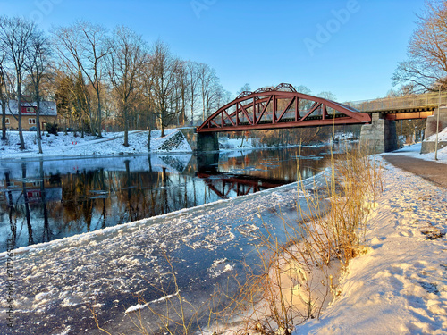 Winter scene with Ronne river and the old historical iron bridge built in 1904 in Angelholm, Sweden.