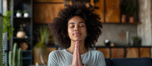 A young woman with Christian faith and gratitude worships and prays in her modern home.