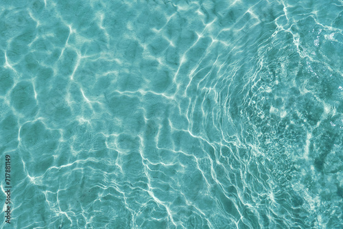 Blue water surface viewed from above in outdoor sea, sun reflection, dimply. Surface Abstract Background. Clear water in sea with ripple in clean aqua liquid. Summer wallpaper blue background