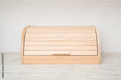 New wooden bread box on table top at home kitchen. Closeup. Front view.