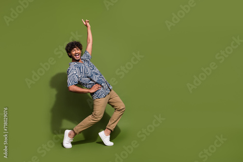 Full body size photo of funny crazy cool mexican guy pointing finger up seems like famous dancer star isolated on khaki color background