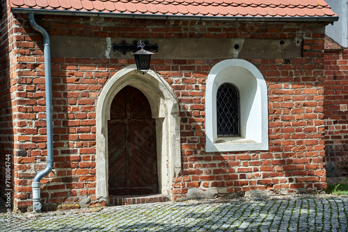 wooden door to a historic, gothic parish church of St. Nativity of the Blessed Virgin Mary in the village of Kamionna