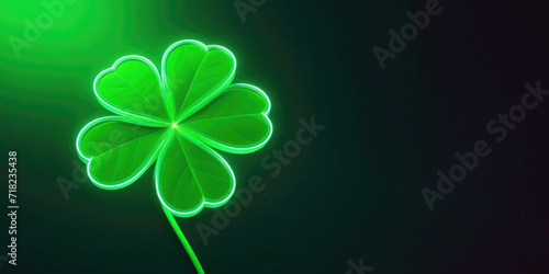 Neon shining four-leaf shamrock banner on Saint Patrick day with copy space on dark green background.