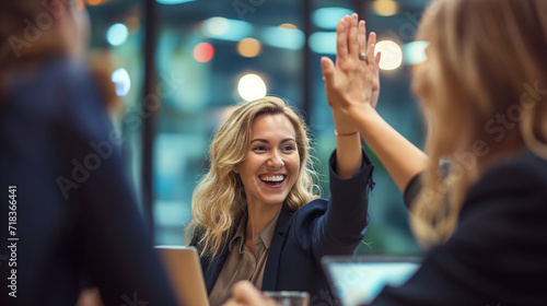 Businesswoman giving a high five to the colleague in meeting room celebrating success. Happy confident business people high-five. Job well done. 