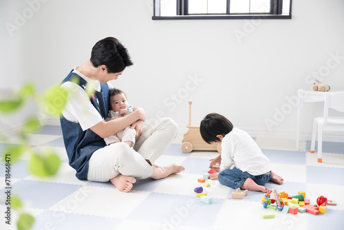 Male childcare worker playing with children at a daycare center. For images such as job hiring career change.