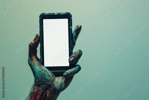 Creepy halloween monster zombie hand holding a mobile phone with a blank screen