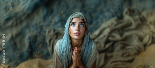 Biblical character. Emotional close up portrait of a woman with blue eyes in a veil looking up and praying.