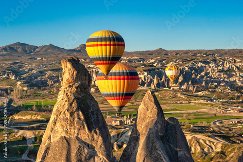 Amazing Cappadocia rocky landscape and balloons at sunrise, view of the valley and canyons.