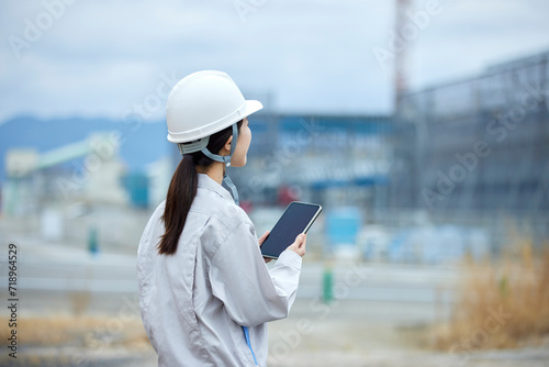 建設現場と作業服を着た女性