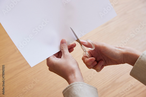 ハサミで紙を切る女性の手元