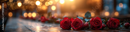 Romantic Valentine's Day celebration with a bouquet of red roses on a wooden table. Elegant panoramic header for websites with space for text. Horizontal still life. Bokeh effect. Love symbol banner