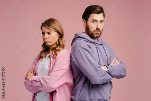 Portrait of offended couple standing and feeling sad with crossed arms 