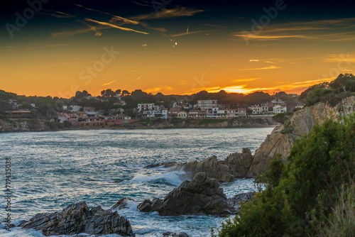 Sunset on the rocky Mediterranean sea shore. Evening at traditional Costa Brava village.