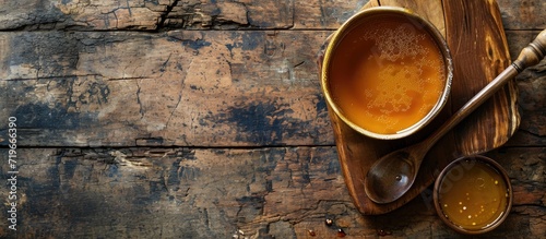 Saucepan with bouillon with a ladle on the table Bone broth. Copy space image. Place for adding text