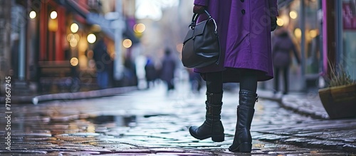 Young woman legs in black ankle boots and purple coat with bag Trendy hipster outfit. Copy space image. Place for adding text