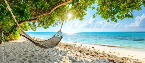 Tropical beach panorama as summer landscape with beach swing or hammock and white sand and calm sea for beach banner Perfect beach scene vacation and summer holiday concept Boost up color proce